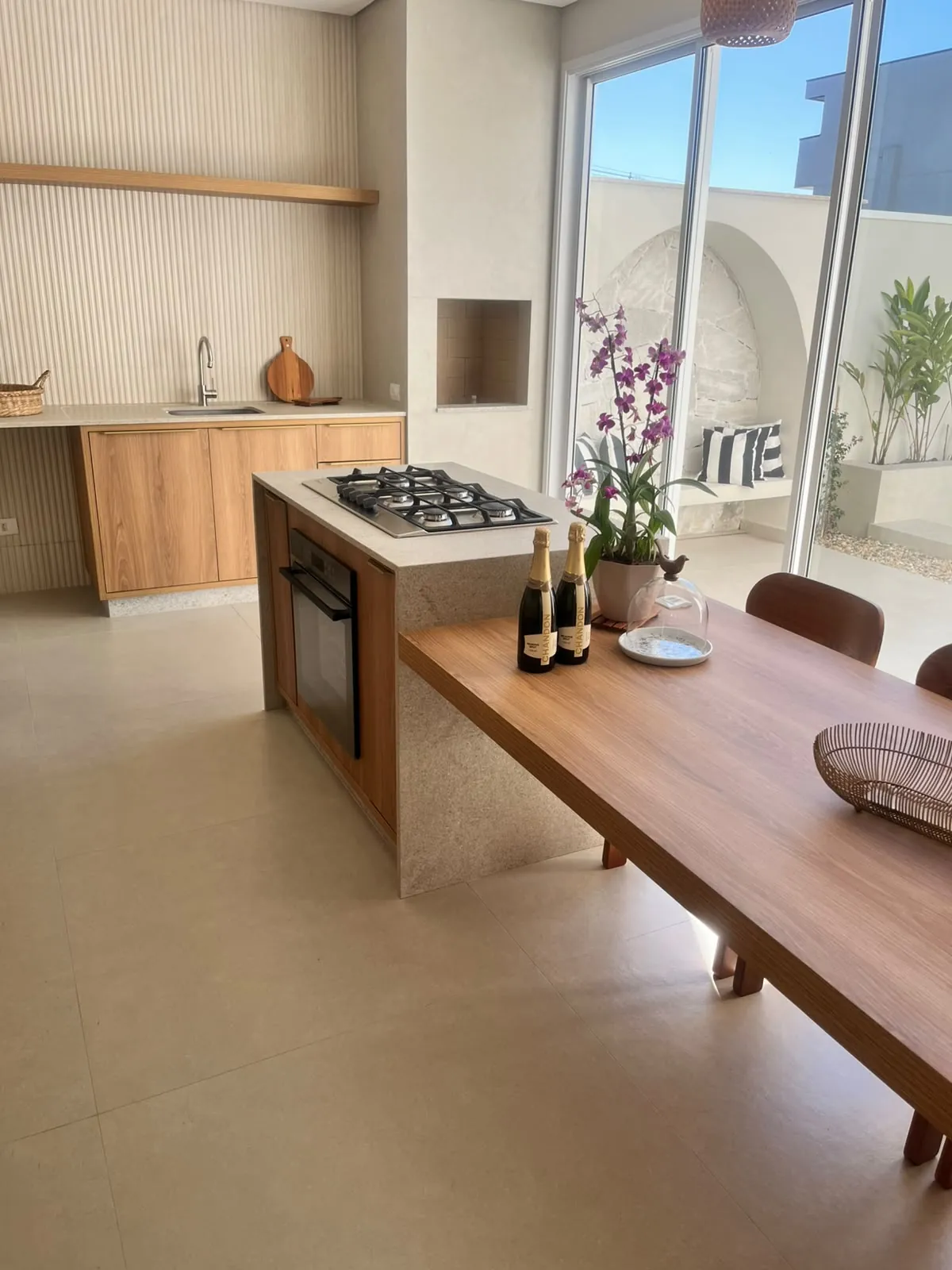 Cozinha com bancada de pedra clara e mesa de madeira integrada